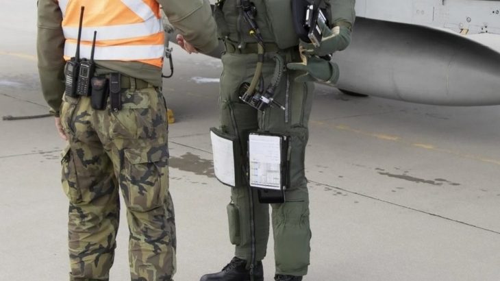 Vojenský pilot stíhacího letounu má papíry nad koleny