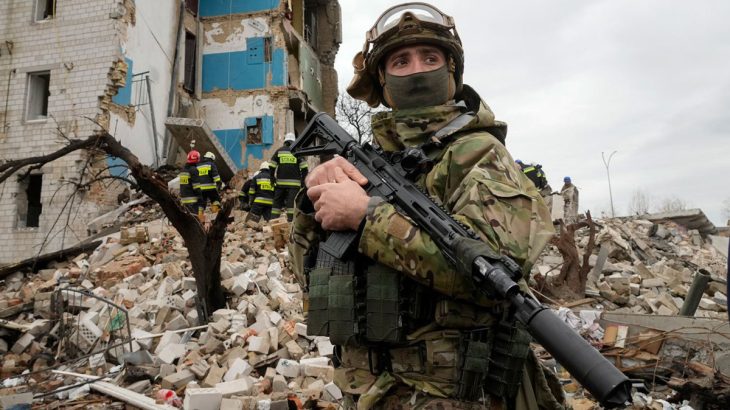 Ukrajinský voják u trosek domu