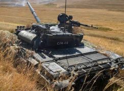 Tank T-72 střílející v poli