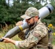 Voják se 120mm tankovým projektilem (granátem)
