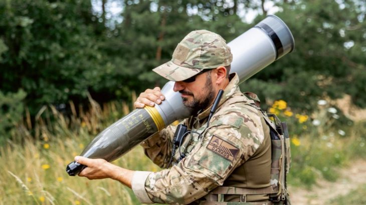 Voják se 120mm tankovým projektilem (granátem)