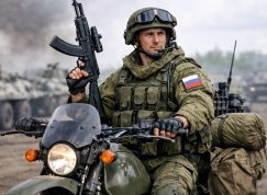 Ruský voják s útočnou puškou na motorce