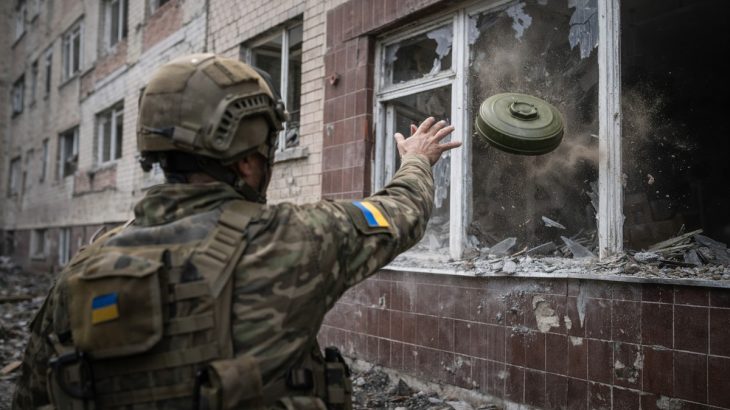 Ukrajinský voják hází protitankovou minu do budovy