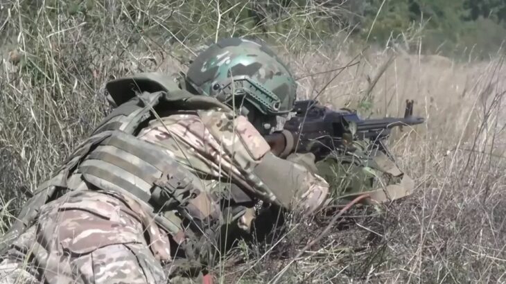 Ruský voják v trávě s kulometem PKM