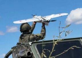 Ruský voják vypouští dron z auta